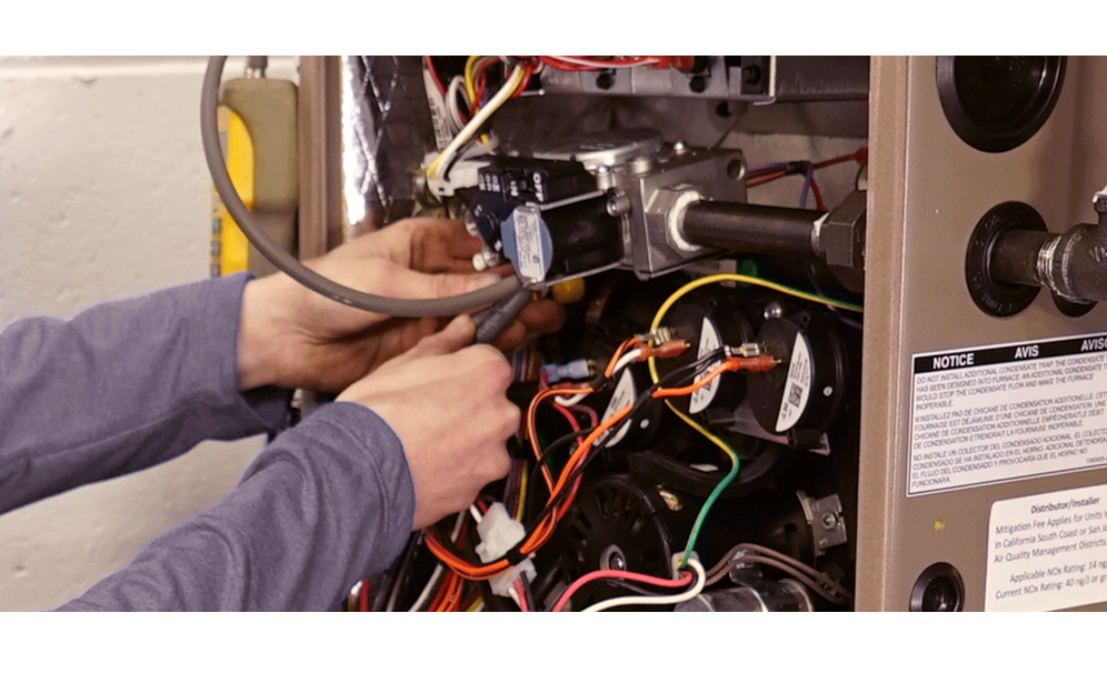 A person's hand fixing an open air conditioner