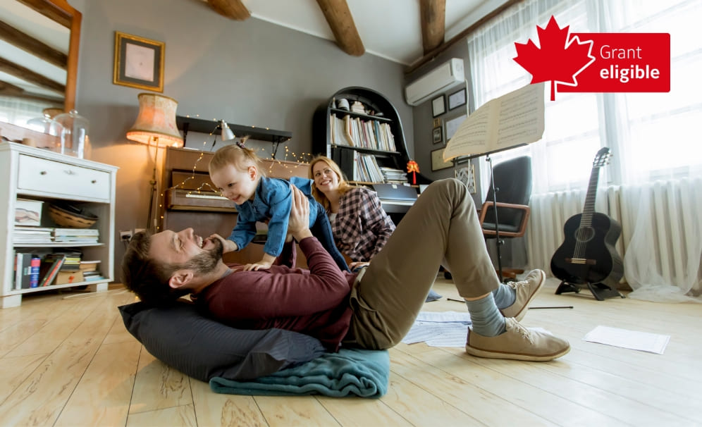 A man and a woman looking at a laptop near a white brick wall.