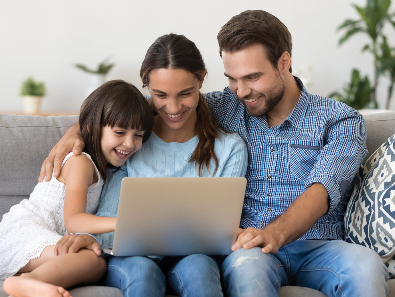 Family on the couch using laptop